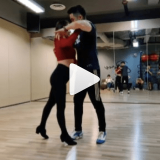 A Couple Dancing in Dance Studio with Onlookers, A Play Button in the Middle